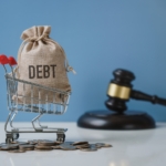 Debt. Money bag and shopping trolley with the hammer of the judge. Concept of financial crisis.